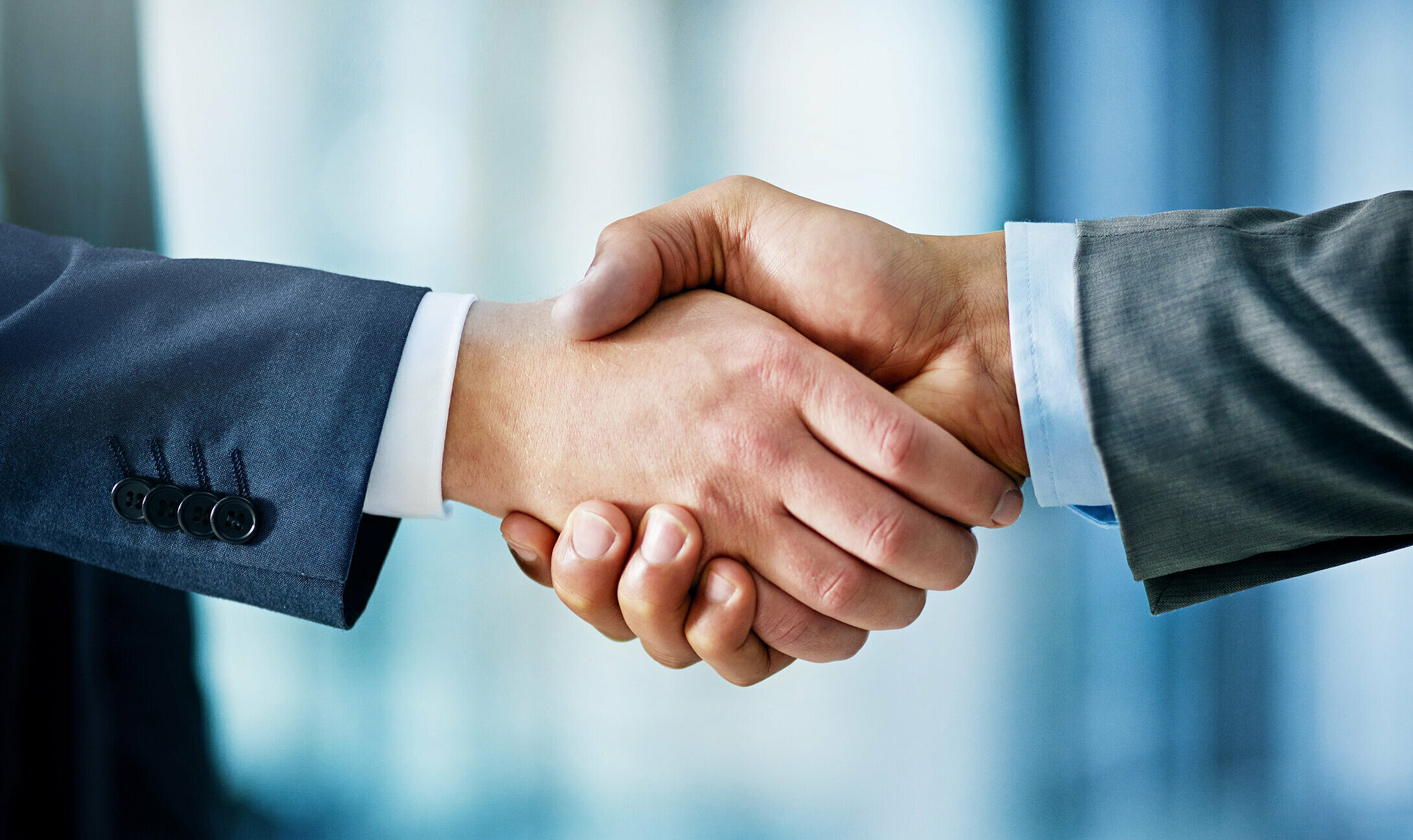 Two businessmen in suits shaking hands