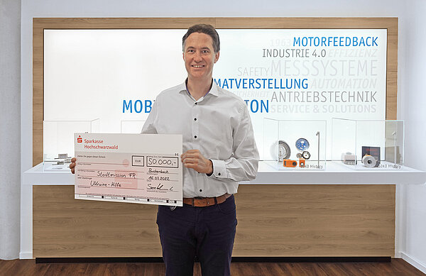 CEO de SIKO con cheque de donación