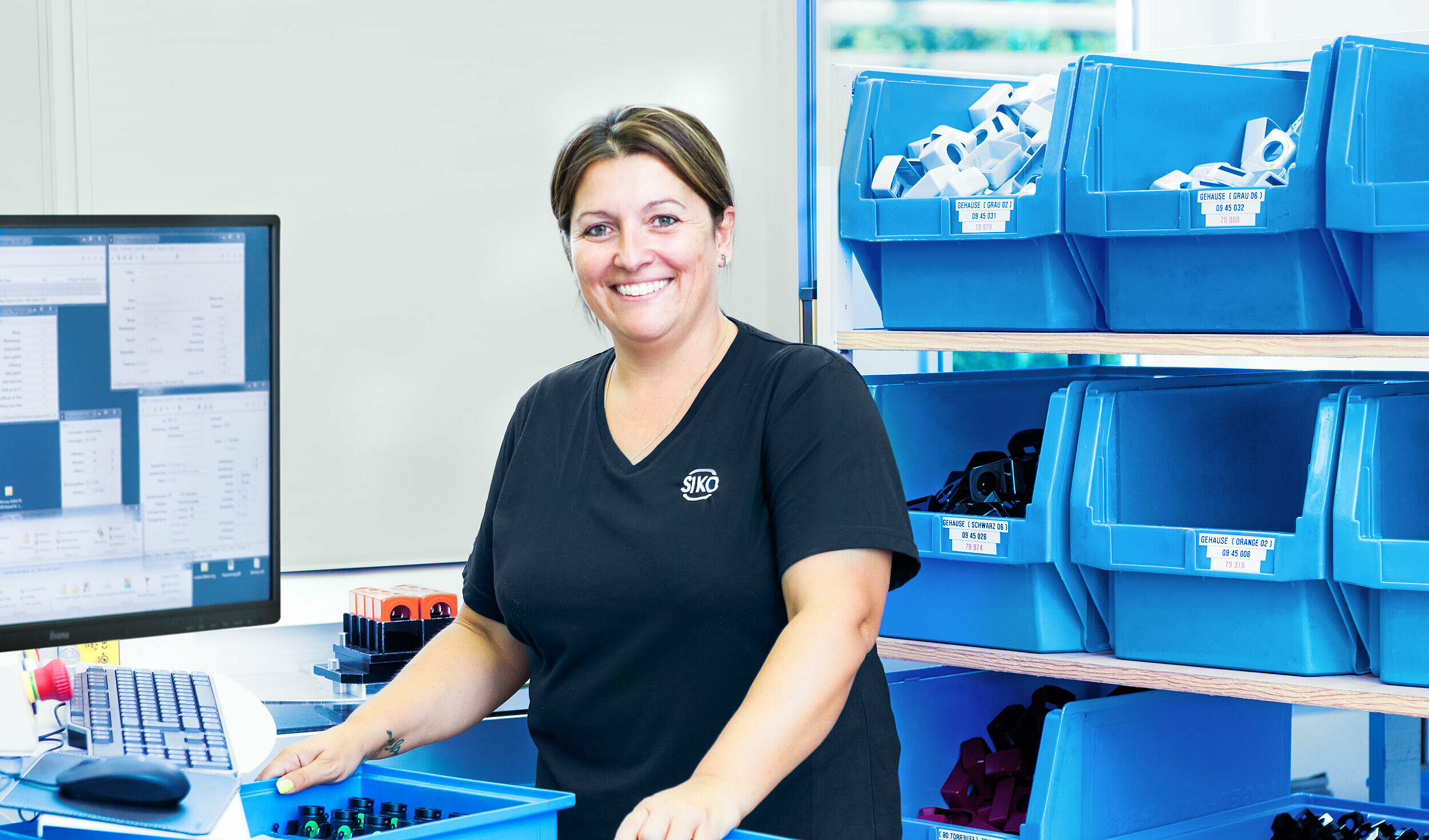 SIKO Mitarbeiterin mit blauen Materialboxen