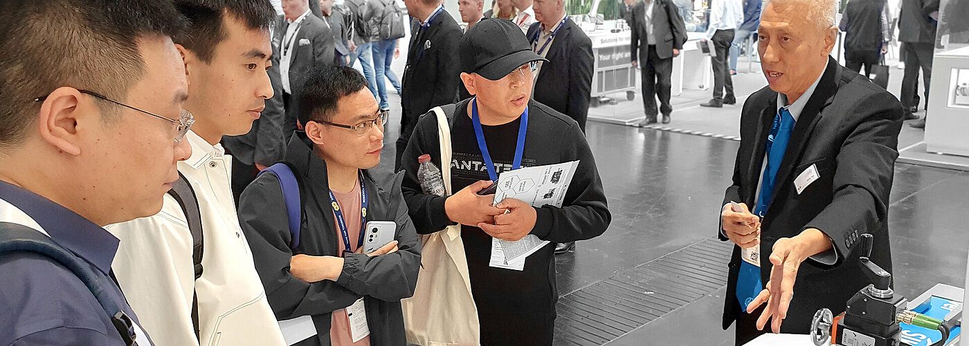 Beratung von asiatischen Interessenten auf einer Messe