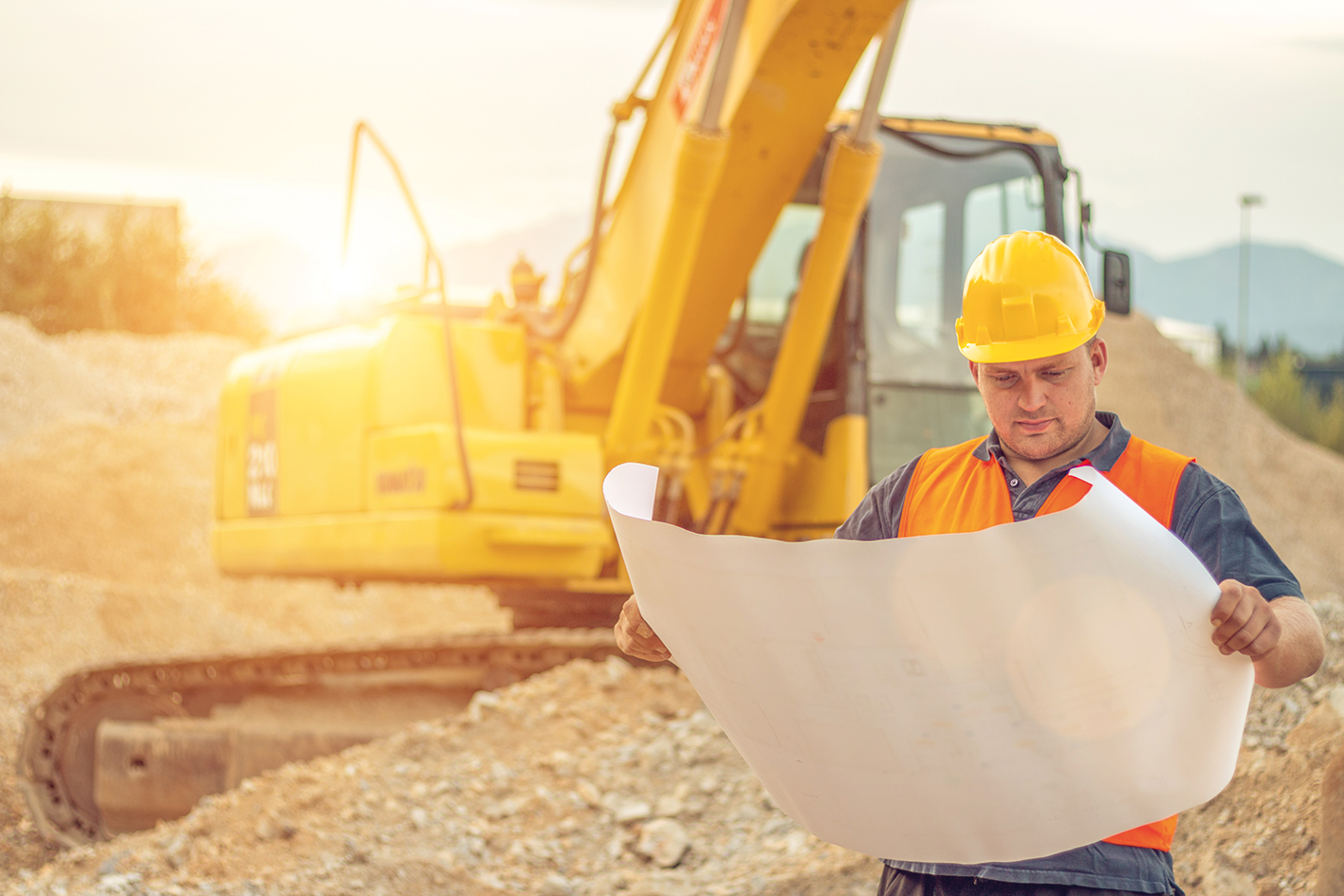 Bauleiter mit Bagger im Hintergrund