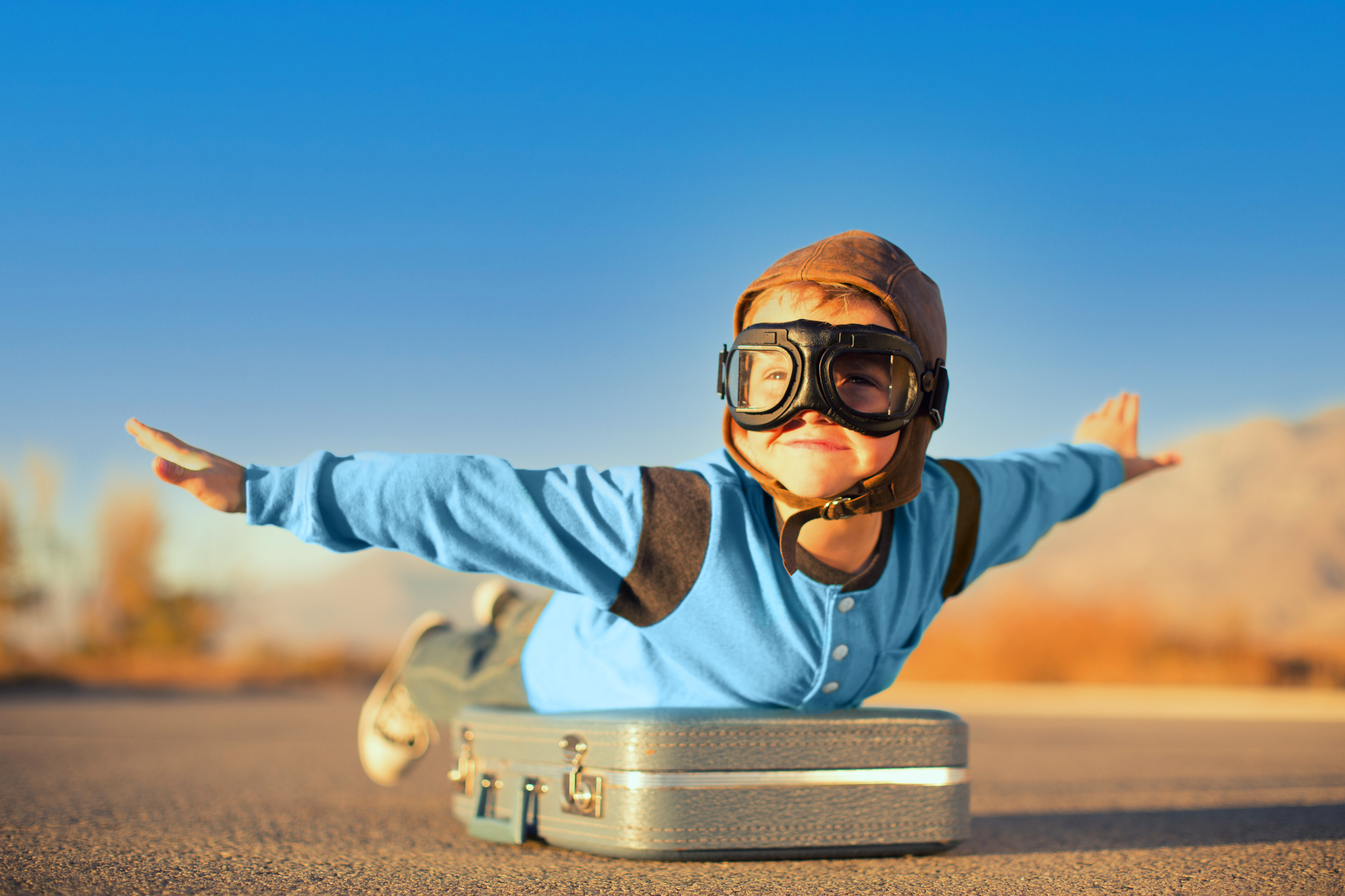 Enfant avec des lunettes d'aviateur en position de vol comme symbole de liberté