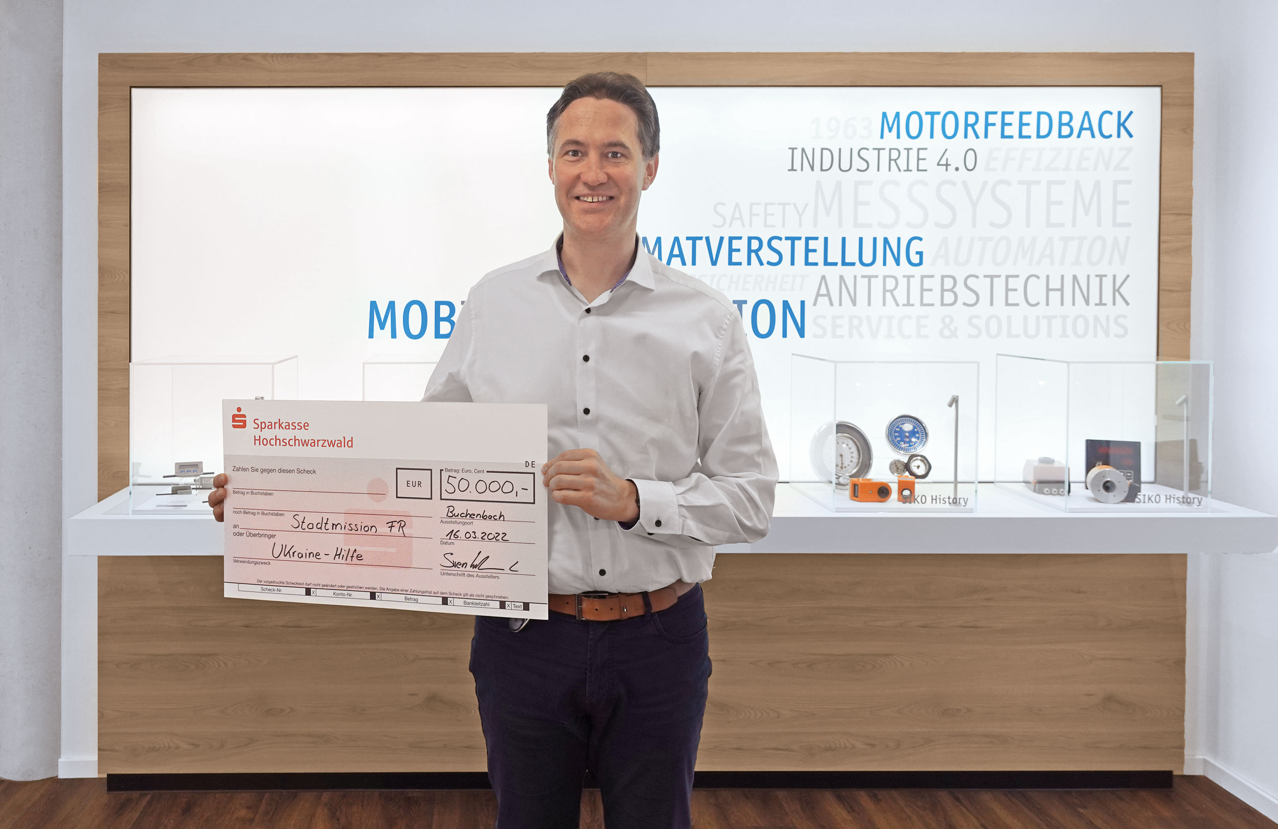 CEO de SIKO con cheque de donación